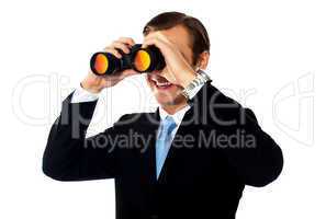 Business professional looking through binoculars