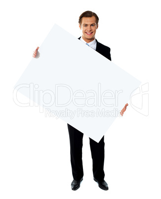 Young corporate male holding tilted blank billboard