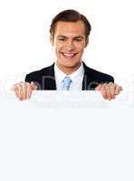 Cool businessman holding a blank poster
