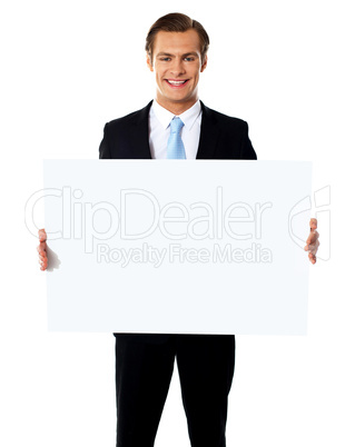 Young businessman holding white blank billboard