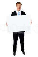 Portrait of businessman showing blank signboard