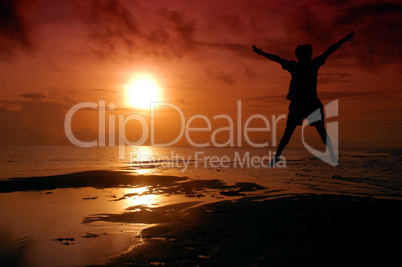 silhouette of a man jumping into the sun