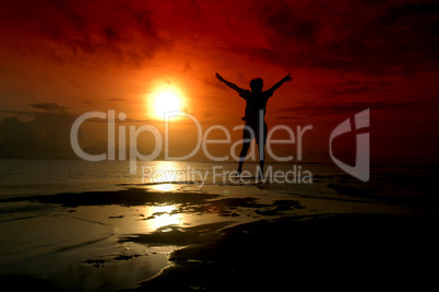 silhouette of a man jumping into the sunrise