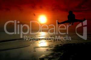 silhouette of a man jumping with sunrise baground