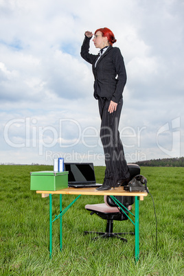 Business woman standing on the desk and looks out