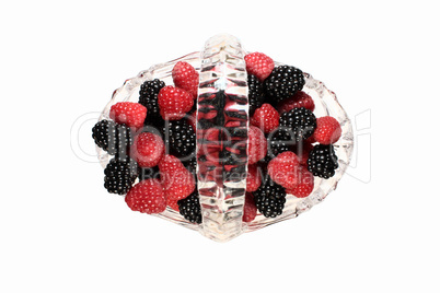 Glass basket full of raspberries and blackberries