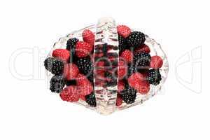 Glass basket full of raspberries and blackberries