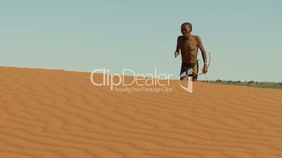 Kalahari bushman walking on blind dune horizon close