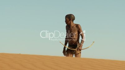 Kalahari bushman walking on blind dune horizon