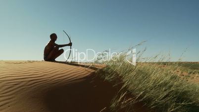 Hunting Kalahari Bushman sitting on dune