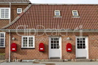 red mailboxes on stone walled house
