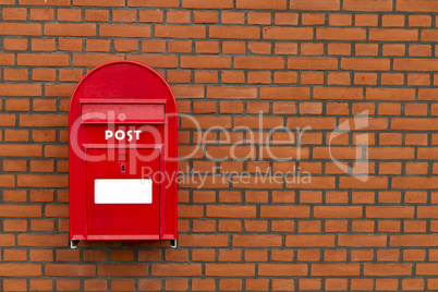 red mailbox on stone wall