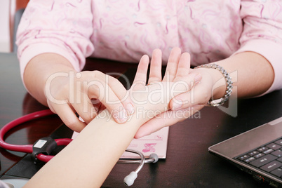 Closeup of a health nurse's hands taking a patient's pulse. Doct