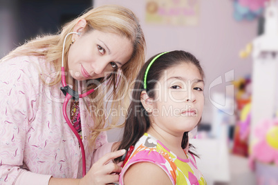 Pediatrician examining little girl with stethoscope