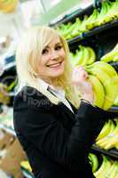 Smiling woman buying bananas