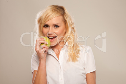 Blonde woman is preparing to bite a green apple