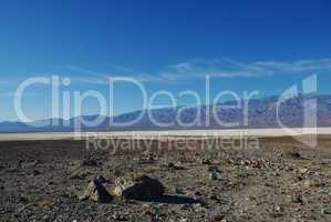 Dispersed rocks, salt flats and high Panamint Range mountains, Death Valley, California
