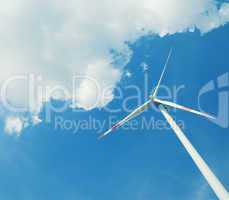 Modern wind energy turbine power station under blue sunny sky with many clouds