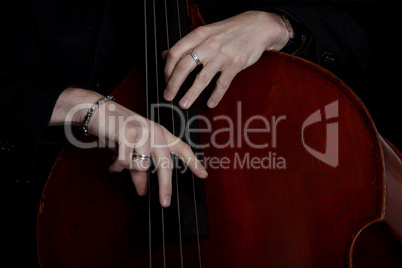 Contrabass player in front of black background