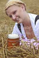 Frau im Dirndl hält ein Bierglas
