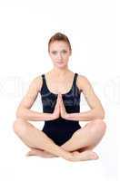 Frau im Lotussitz faltet die Hände zur Meditation