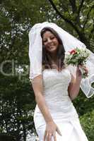 lächelnde Frau in weißem Hochzeitskleid