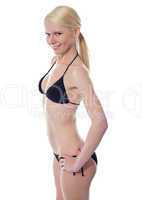 The slim suntanned girl in bikini