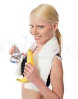 Fitness girl holding water bottle and banana