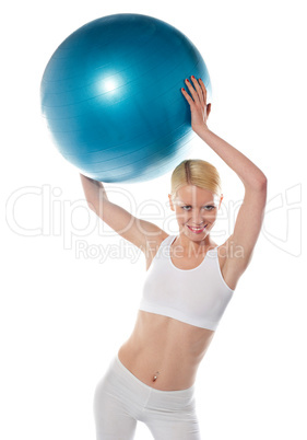 Female athlete holding blue ball, studio shot