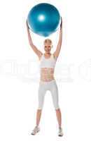 Sporty woman holding ball over her head