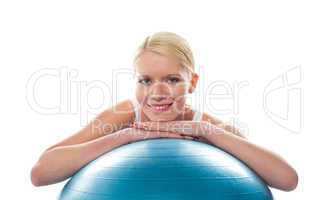 Attractive fit young woman resting chin over ball