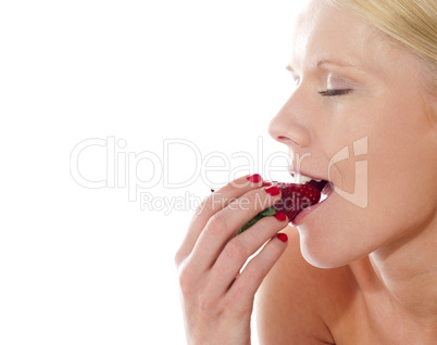 Young beautiful caucasian lady tasting yummy strawberry