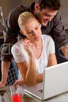 couple at home woman using laptop