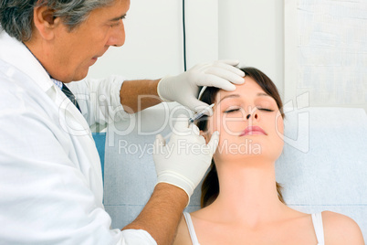 young caucasian woman receiving an injection of botox from a doc
