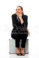 Young businesswoman sitting on a briefcase on white background s