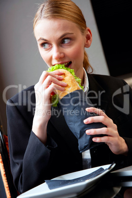 young businesswoman eating a sandwich