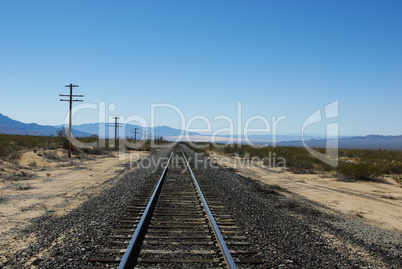 Railway track with Mojave Dunes and Providence Mountains in the distance, California