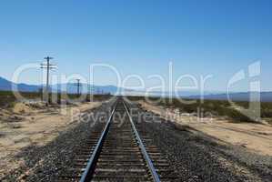 Railway track with Mojave Dunes and Providence Mountains in the distance, California