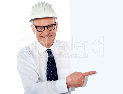 Senior man in white construction helmet holding placard