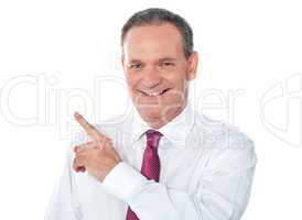 Smiling businessman pointing away