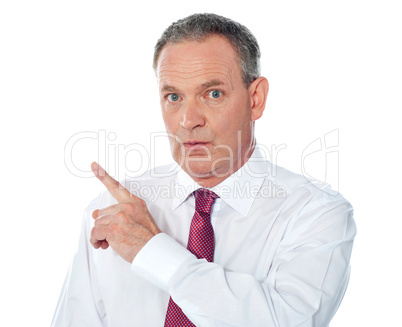 Portrait of senior businessman pointing backwards