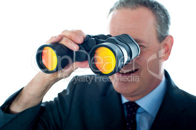 Senior man observing through binoculars