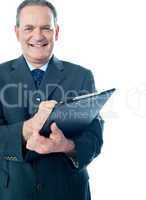 Businessman writing on clipboard