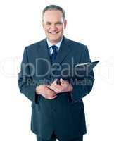 Smiling elderly businessman holding clipboard