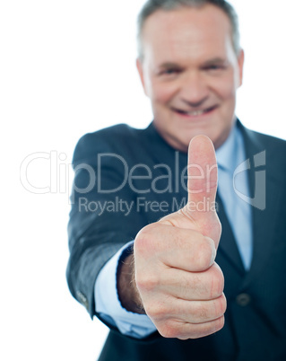 Smiling matured businessman showing thumbs-up