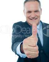 Smiling matured businessman showing thumbs-up