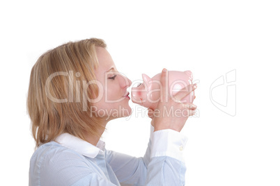 Junge Frau hält ein rosa Sparschwein in der Hand will es küssen