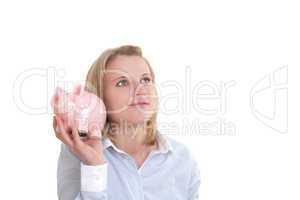 Junge blonde Frau hält ein Sparschwein in der Hand und grübelt nach