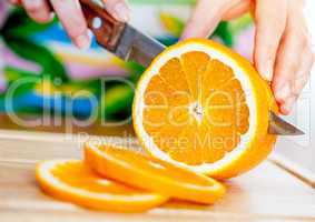 Woman's hands cutting orange