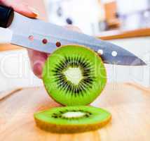 Woman's hands cutting kiwi